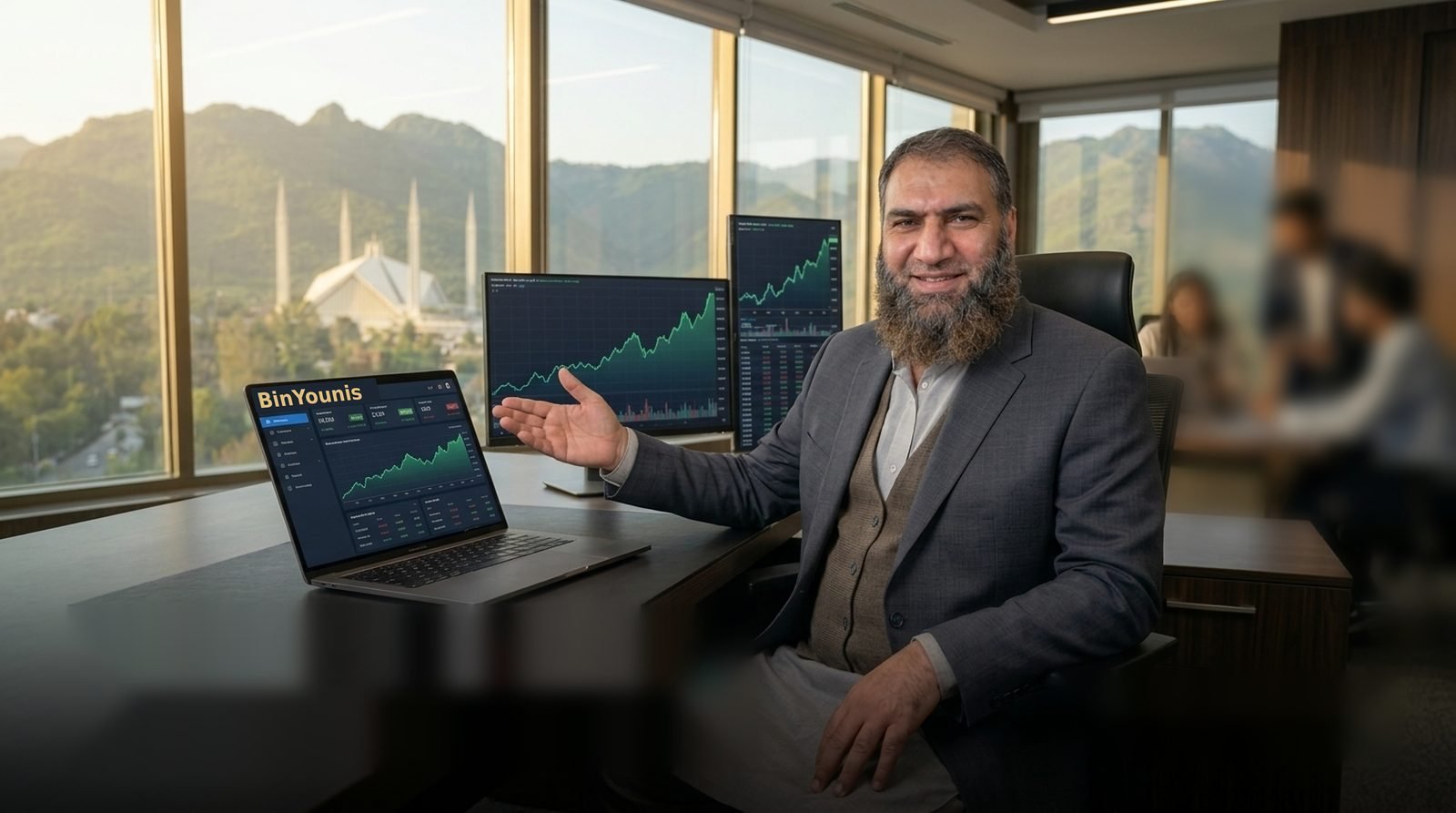 Abdul Qayyum, founder of BinYounis, in his office with dashboards on screen and Faisal Mosque and the Margalla Hills behind him